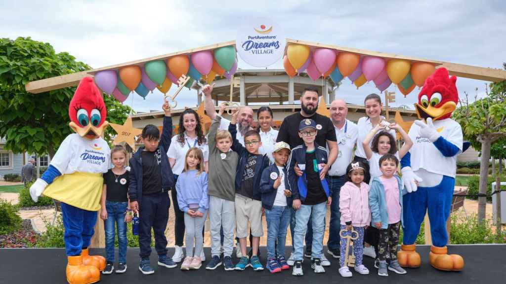 Voluntarios y niños acompañados de las mascotas de PortAventura en la inauguración de PortAventura Dreams Village