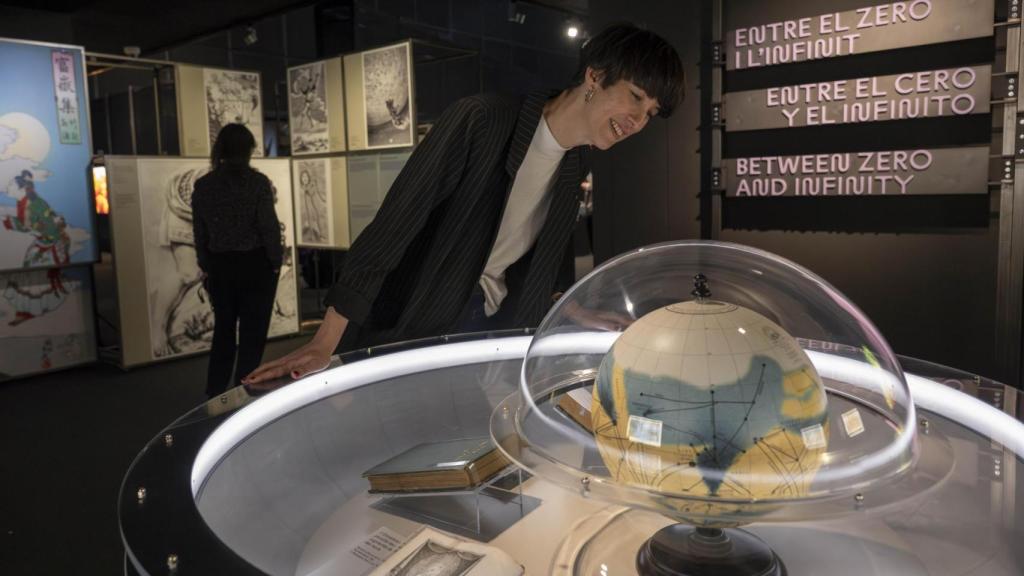 Una visitante contempla los libros históricos que contiene la exposición