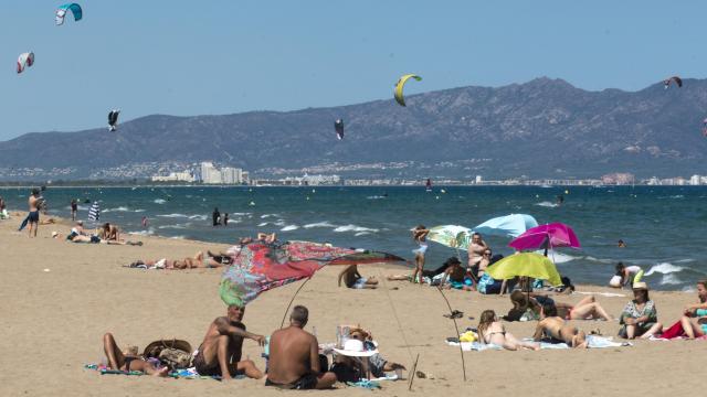 Varias personas disfrutan de un día de playa en Sant Pere Pescador