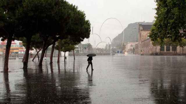 Un hombre paseando bajo la lluvia en Barcelona