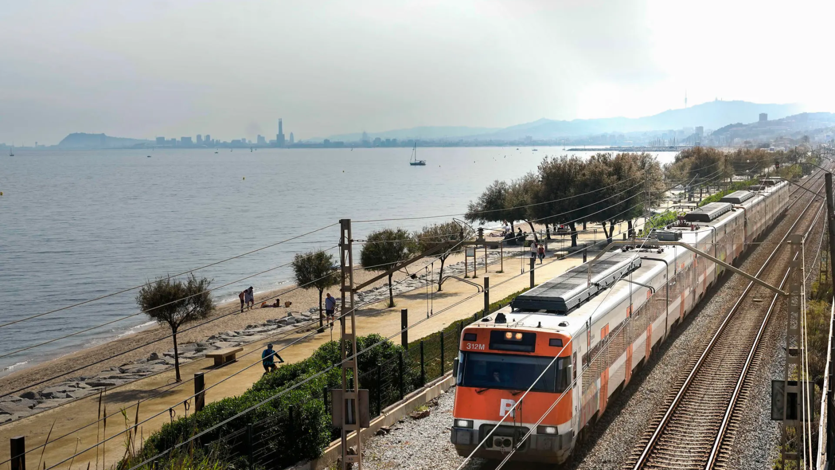 Tren de Rodalies con Barcelona al fondo.